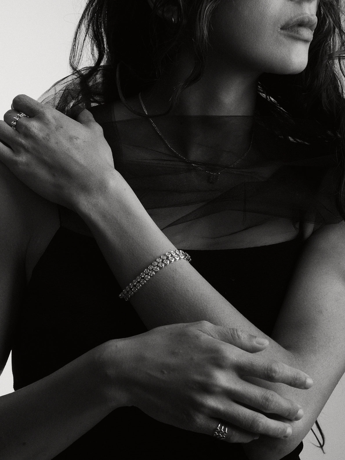 Close-up of person wering two stacked Roller bracelets in white gold in a monochromatic style